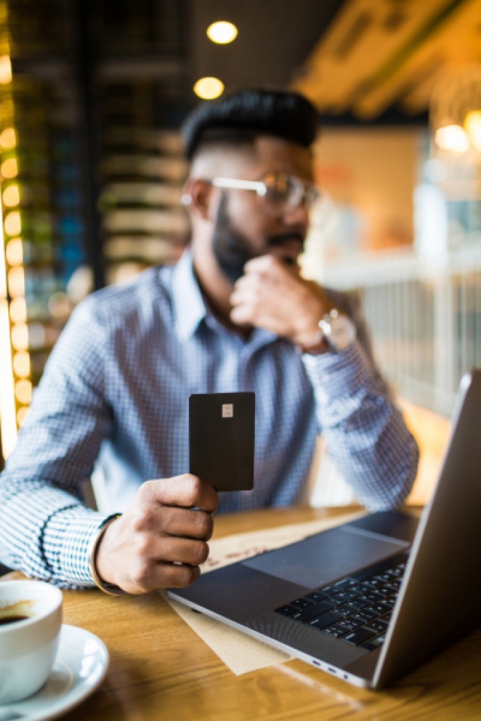 Middle eastern man in cafe paying with credit card