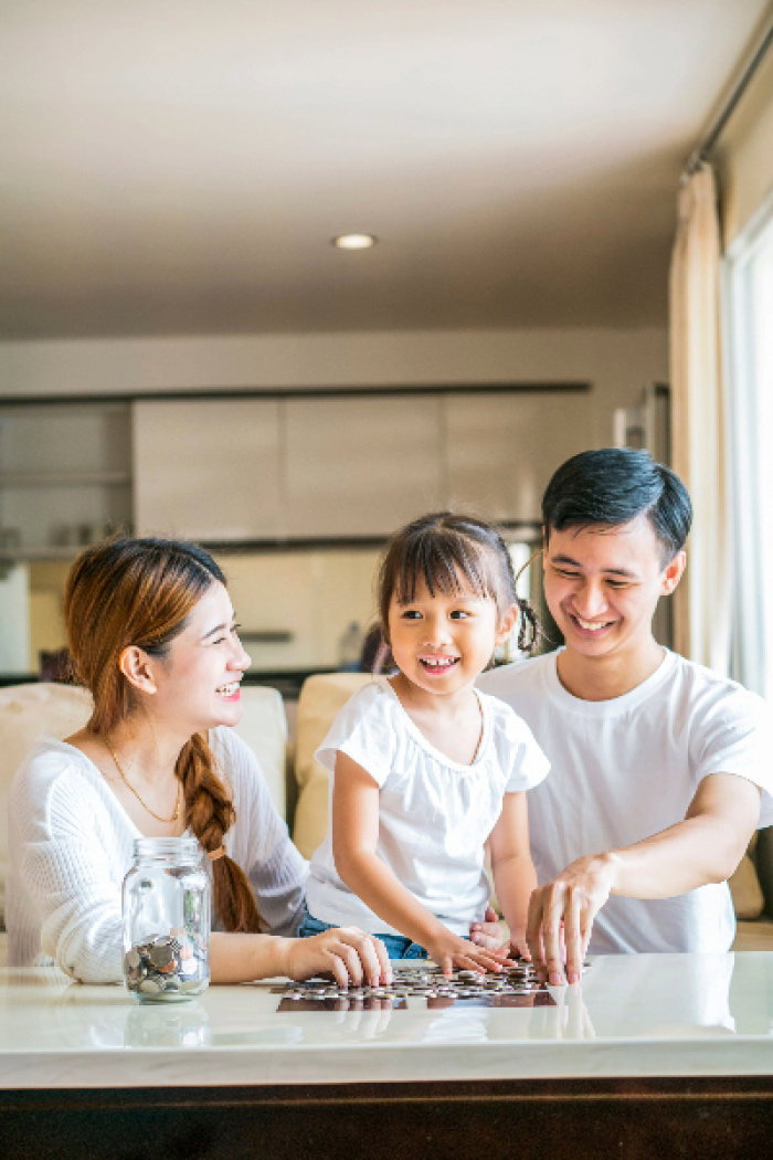 Parents teaching their daughter about savings