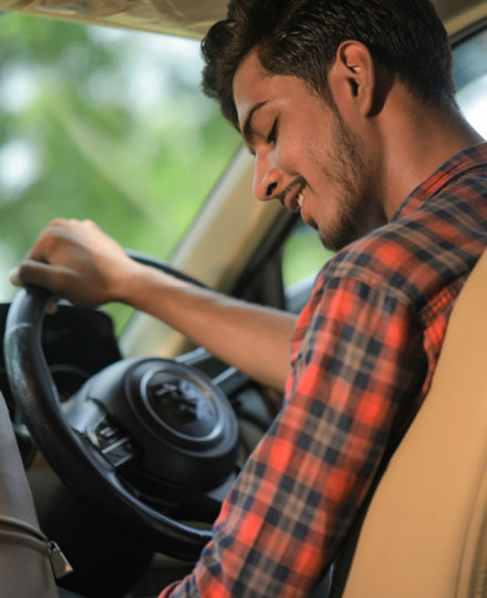 Young adult driving his car.