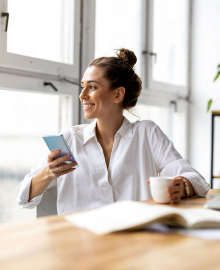 Business woman enjoying her morning while reviewing her bank statements.