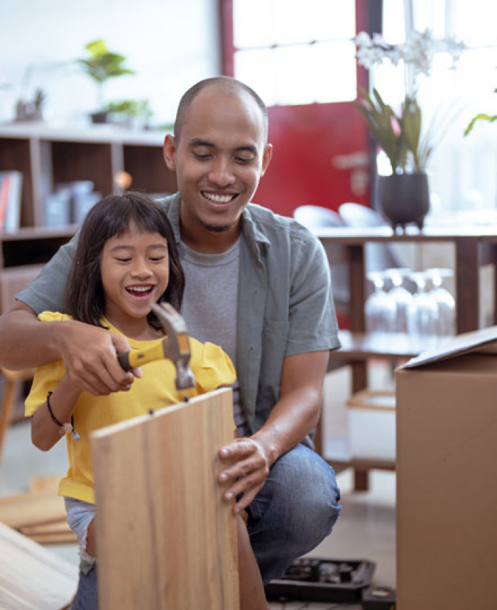 Father and child assembling furniture after a move.