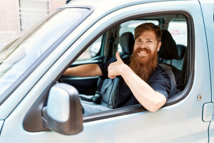 Man giving thumbs up in his car