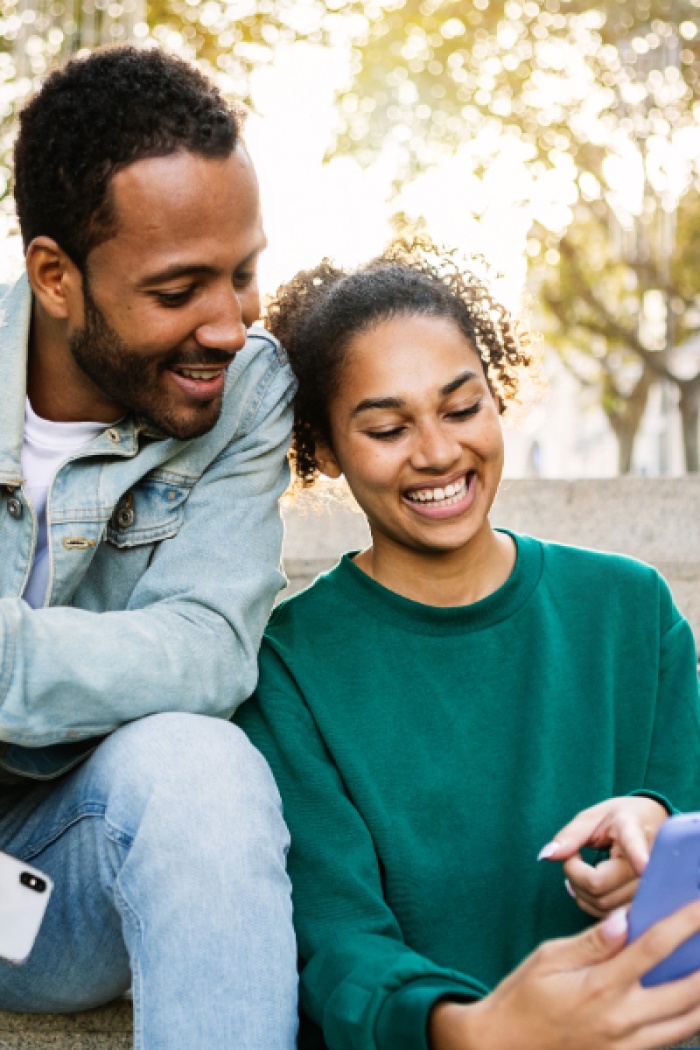 Young couple smiling at phone