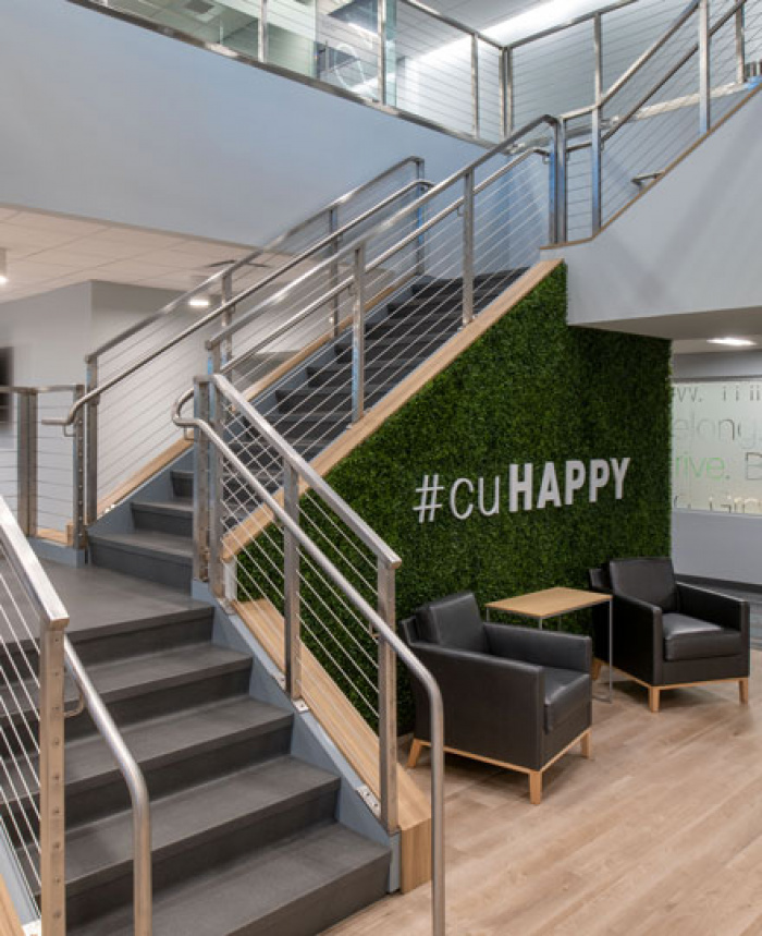 Open staircase with sign on ivy wall that reads #cuHAPPY