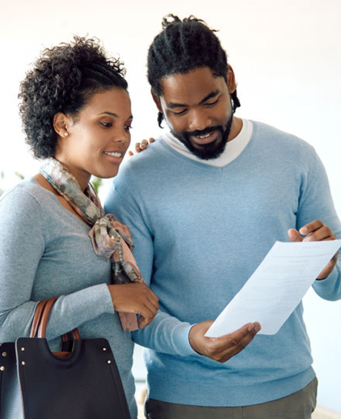 Smiling couple reviewing a document held by the man