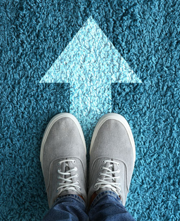 Person standing on forward arrow