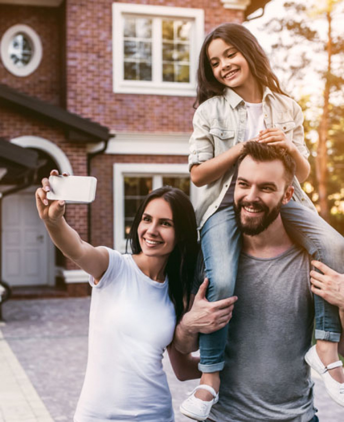 Family outside new home taking selfie
