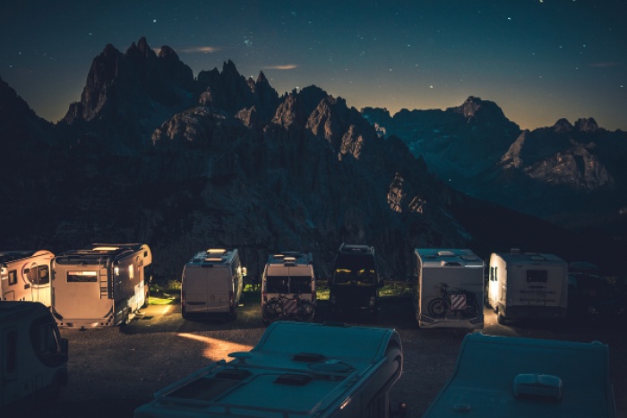 multiple recreational vehicles parked at base of mountains