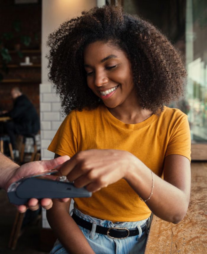 Woman at coffee shop using contactless card