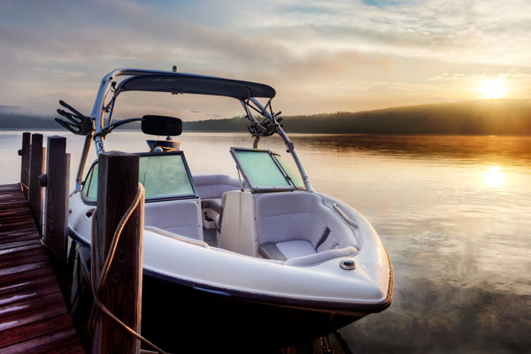 Boat docked in bay at sunset