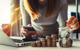 woman counting coins and placing into a jar